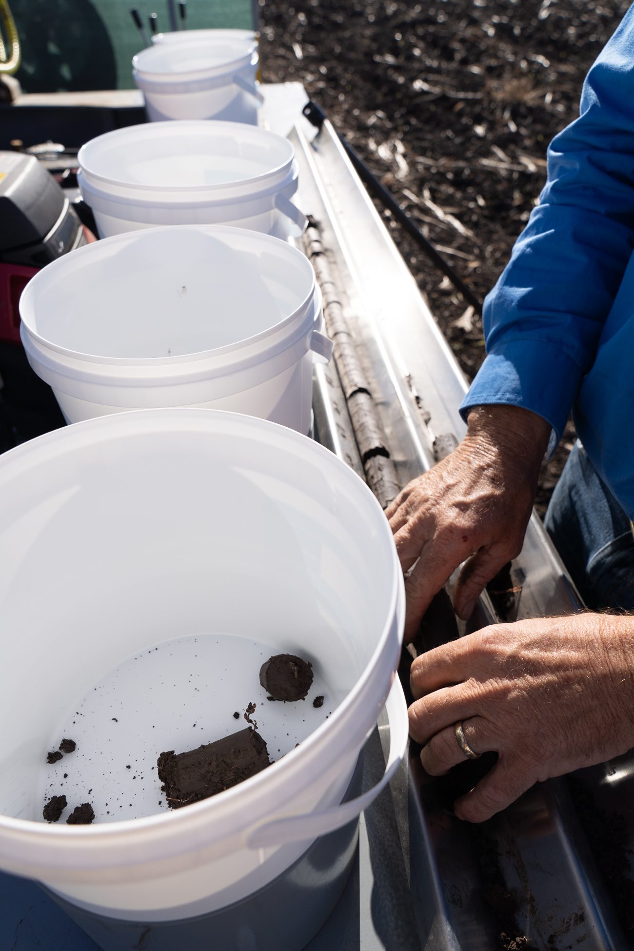Soil sample being placed in a sampling bucket beside a Dawson Ag soil testing rig in a broadacre paddock, Southern Queensland.